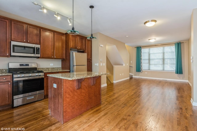 1240 W Monroe St Unit 7, Chicago, IL 60607 - kitchen featuring appliances with stainless steel finishes, a breakfast bar area, wood finished floors, and a center island