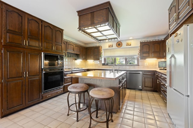 10 Shoreside Dr, South Barrington, IL 60010 - kitchen with black appliances, light tile patterned flooring, light countertops, and decorative backsplash