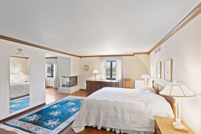 10 Shoreside Dr, South Barrington, IL 60010 - bedroom with ornamental molding, multiple windows, wood finished floors, and a multi sided fireplace