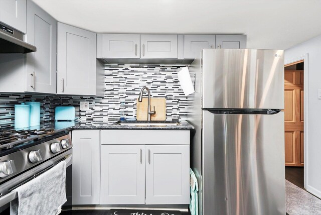 3115 N Marmora Ave, Chicago, IL 60634 - kitchen with appliances with stainless steel finishes, wall chimney exhaust hood, tasteful backsplash, and dark stone counters