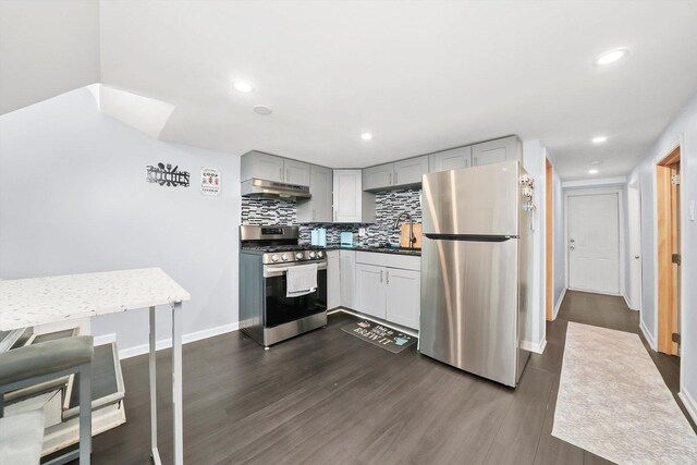 3115 N Marmora Ave, Chicago, IL 60634 - kitchen featuring appliances with stainless steel finishes, under cabinet range hood, dark wood-style floors, backsplash, and recessed lighting