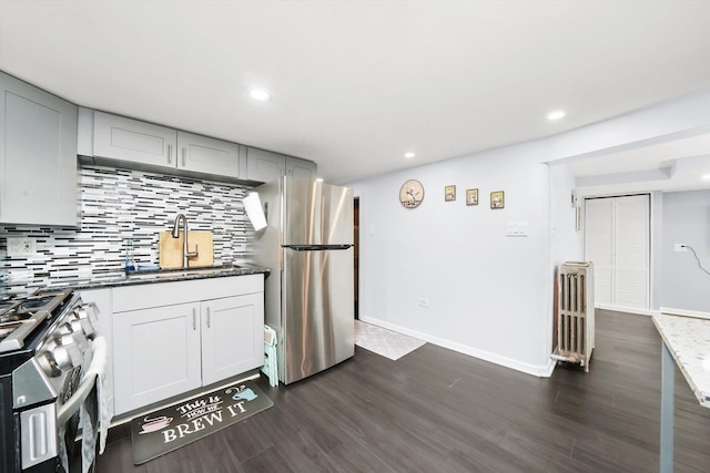 3115 N Marmora Ave, Chicago, IL 60634 - kitchen featuring appliances with stainless steel finishes, dark wood-type flooring, tasteful backsplash, dark stone countertops, and recessed lighting
