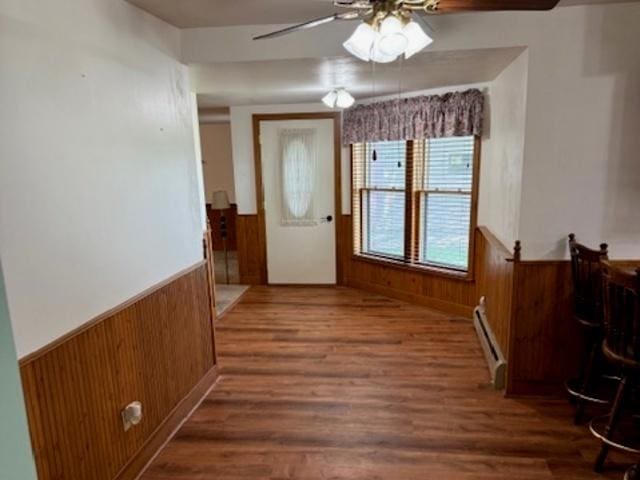 12238 Lisbon Rd, Newark, IL 60541 - entryway with a baseboard heating unit, a ceiling fan, a wainscoted wall, wood walls, and wood finished floors