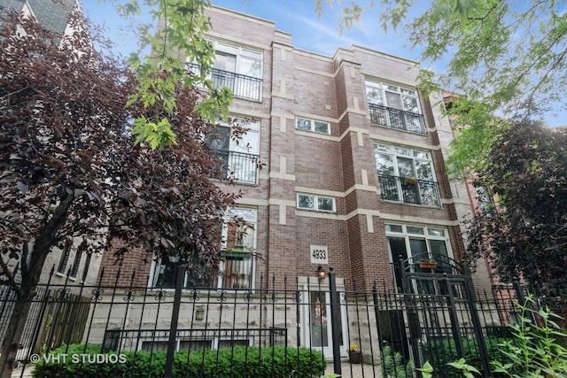 4933 N Winthrop Ave Unit 2S, Chicago, IL 60640 - view of building exterior featuring a fenced front yard