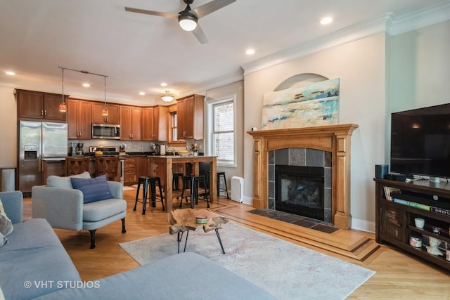 4933 N Winthrop Ave Unit 2S, Chicago, IL 60640 - living area with crown molding, ceiling fan, light wood-style floors, a tile fireplace, and recessed lighting