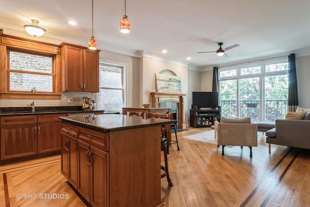 4933 N Winthrop Ave Unit 2S, Chicago, IL 60640 - kitchen with open floor plan, a kitchen bar, ceiling fan, crown molding, and a center island