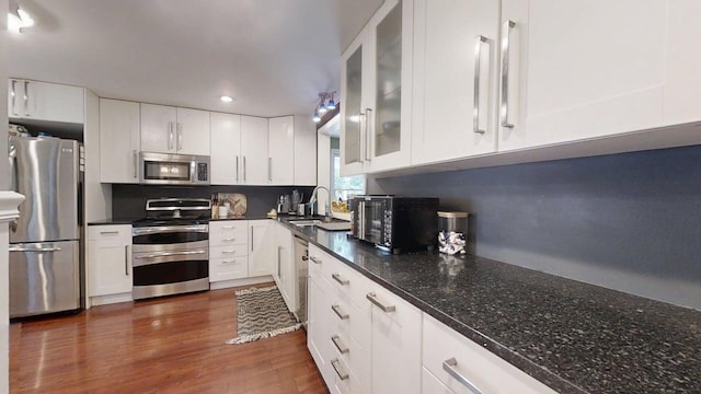 16 W George St, Sullivan, IL 61951 - kitchen featuring appliances with stainless steel finishes, white cabinetry, glass insert cabinets, dark wood-type flooring, and recessed lighting