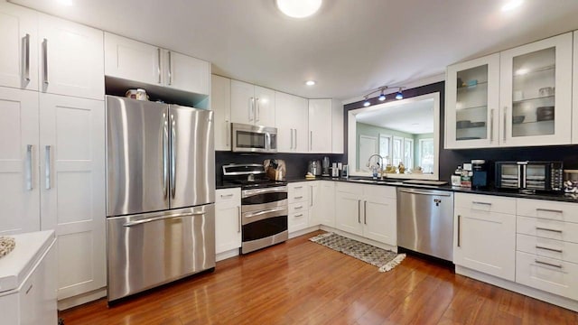 16 W George St, Sullivan, IL 61951 - kitchen featuring stainless steel appliances, glass insert cabinets, white cabinets, wood finished floors, and recessed lighting