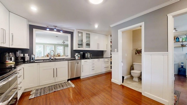 16 W George St, Sullivan, IL 61951 - kitchen featuring appliances with stainless steel finishes, ornamental molding, ceiling fan, glass insert cabinets, and wood finished floors