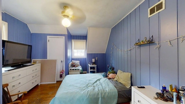 16 W George St, Sullivan, IL 61951 - bedroom featuring dark wood-style flooring, a ceiling fan, and wooden walls