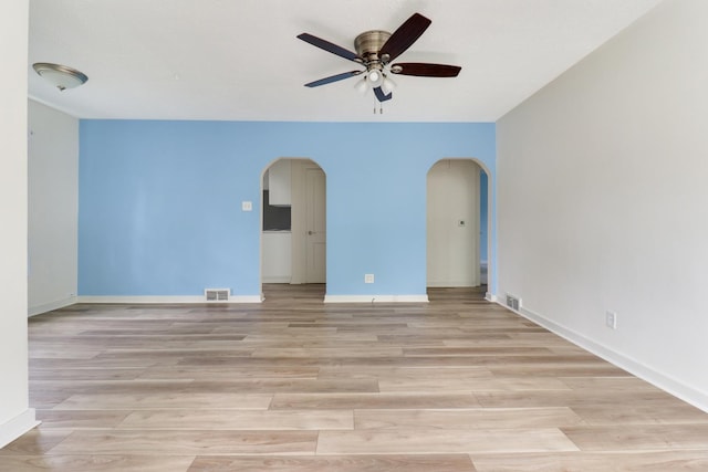 103 S Portland Pl, Clinton, IL 61727 - empty room featuring arched walkways, a ceiling fan, and light wood-style flooring