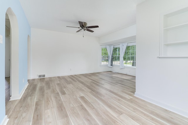 103 S Portland Pl, Clinton, IL 61727 - empty room with arched walkways, ceiling fan, and light wood-style flooring