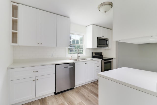 103 S Portland Pl, Clinton, IL 61727 - kitchen with stainless steel appliances, tasteful backsplash, light wood finished floors, and white cabinetry
