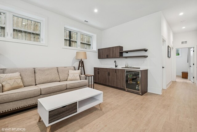 4535 S Evans Ave, Chicago, IL 60653 - living area featuring beverage cooler, wet bar, light wood finished floors, healthy amount of natural light, and recessed lighting