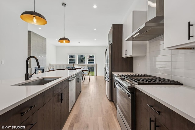 4535 S Evans Ave, Chicago, IL 60653 - kitchen featuring appliances with stainless steel finishes, wall chimney range hood, light countertops, dark brown cabinets, and recessed lighting