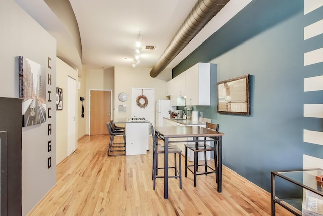910 S Michigan Ave Unit 1005, Chicago, IL 60605 - kitchen featuring light wood finished floors, white cabinetry, a breakfast bar area, freestanding refrigerator, and track lighting