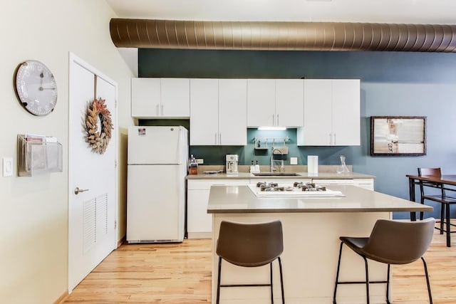 910 S Michigan Ave Unit 1005, Chicago, IL 60605 - kitchen with white appliances, a kitchen breakfast bar, light wood-style floors, white cabinetry, and light countertops