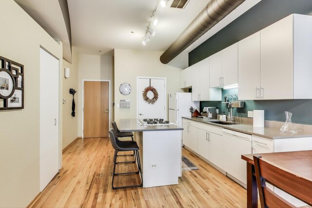 910 S Michigan Ave Unit 1005, Chicago, IL 60605 - kitchen with dishwasher, white cabinetry, a kitchen island, light wood-style floors, and a breakfast bar