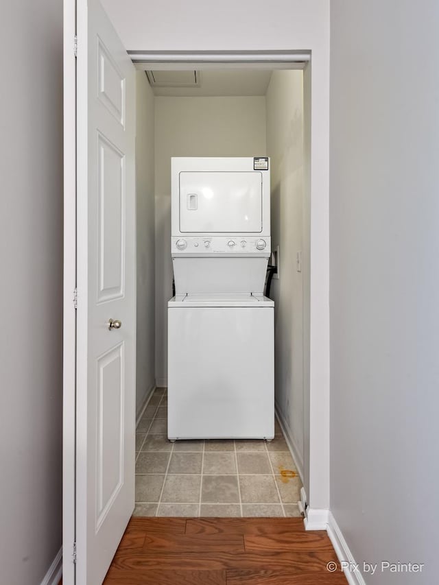 930 Curtiss St Unit 104, Downers Grove, IL 60515 - washroom featuring estacked washer and dryer and light tile patterned floors