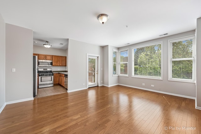930 Curtiss St Unit 104, Downers Grove, IL 60515 - unfurnished living room featuring baseboards and light wood-style floors