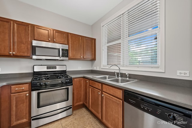 930 Curtiss St Unit 104, Downers Grove, IL 60515 - kitchen with stainless steel appliances, light tile patterned flooring, brown cabinetry, and dark countertops