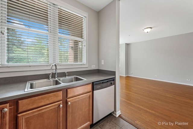 930 Curtiss St Unit 104, Downers Grove, IL 60515 - kitchen with stainless steel dishwasher, brown cabinets, dark countertops, and wood finished floors