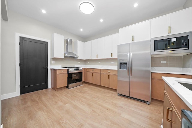7719 S Morgan St, Chicago, IL 60620 - kitchen featuring appliances with stainless steel finishes, wall chimney exhaust hood, light countertops, light wood-style floors, and recessed lighting