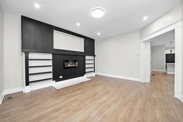 7719 S Morgan St, Chicago, IL 60620 - unfurnished living room featuring light wood-style floors, a glass covered fireplace, and recessed lighting