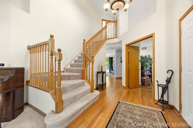 908 Pimpernel Ct, Naperville, IL 60540 - entryway featuring wood finished floors, a chandelier, stairs, and a towering ceiling