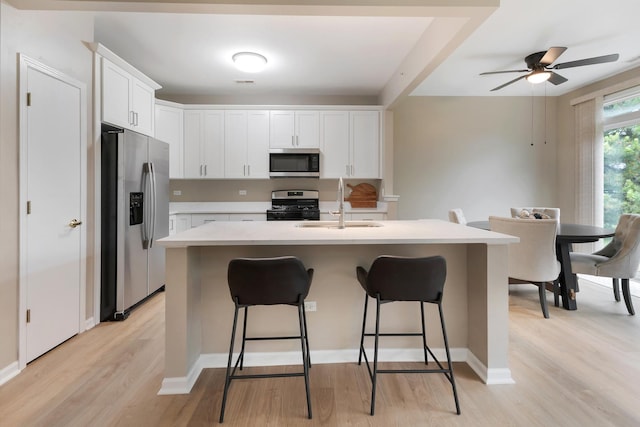13315 Red Alder Ave, Huntley, IL 60142 - kitchen with stainless steel appliances, light wood-style floors, a kitchen breakfast bar, light countertops, and white cabinets