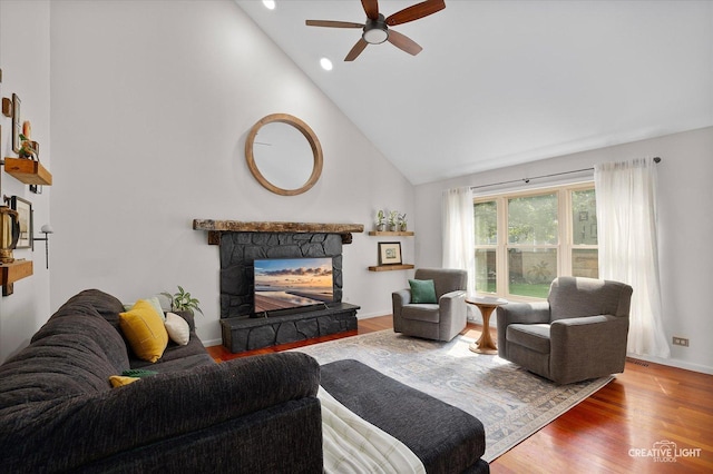 25048 Michele Dr, Plainfield, IL 60544 - living room with high vaulted ceiling, a ceiling fan, wood finished floors, a stone fireplace, and recessed lighting