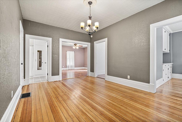 605 W 2nd N St, Wenona, IL 61377 - unfurnished room featuring a chandelier, light wood finished floors, a textured wall, and ceiling fan