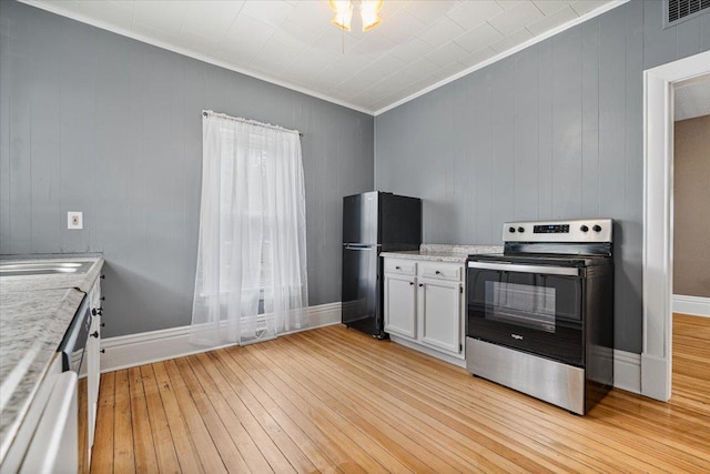 605 W 2nd N St, Wenona, IL 61377 - kitchen featuring stainless steel electric range oven, freestanding refrigerator, crown molding, light wood finished floors, and white cabinets