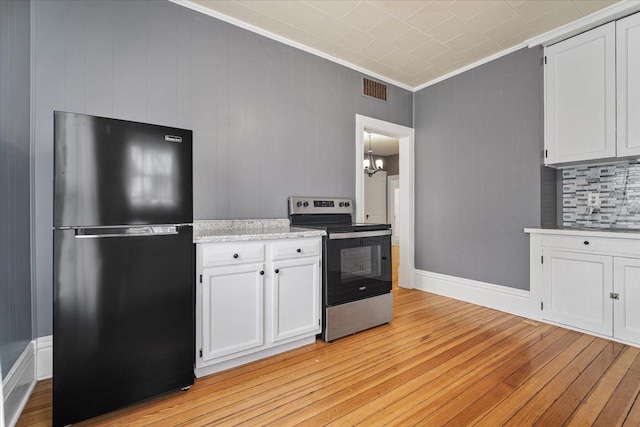 605 W 2nd N St, Wenona, IL 61377 - kitchen featuring freestanding refrigerator, stainless steel electric range, light wood-style floors, a chandelier, and white cabinetry
