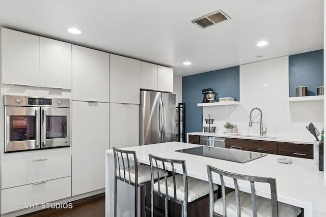 424 Park Ave Unit 604, River Forest, IL 60305 - kitchen featuring open shelves, appliances with stainless steel finishes, a breakfast bar area, light countertops, and recessed lighting