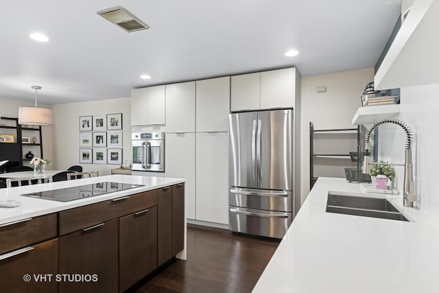 424 Park Ave Unit 604, River Forest, IL 60305 - kitchen featuring appliances with stainless steel finishes, light countertops, dark brown cabinetry, dark wood-style floors, and white cabinetry