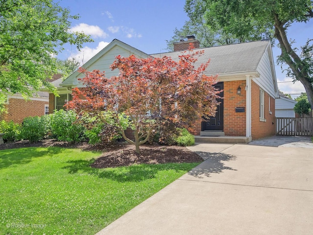 610 S Madison Ave, La Grange, IL 60525 - view of property hidden behind natural elements featuring a front lawn, a chimney, brick siding, and a shingled roof