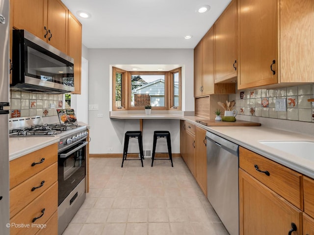 610 S Madison Ave, La Grange, IL 60525 - kitchen featuring appliances with stainless steel finishes, decorative backsplash, light countertops, and recessed lighting