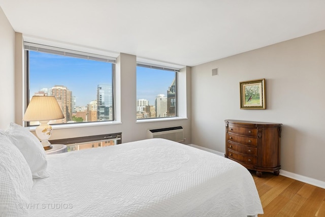 1110 N Lake Shore Dr Unit 20N, Chicago, IL 60611 - bedroom with wood finished floors, a wall mounted air conditioner, and a view of skyline