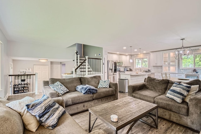 1322 E Thurston Dr, Palatine, IL 60074 - living room featuring light wood-type flooring, plenty of natural light, a chandelier, and stairs