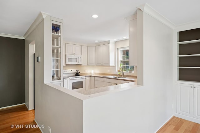 1503 Oak Ave Unit 312, Evanston, IL 60201 - kitchen featuring white appliances, light wood-style floors, crown molding, a peninsula, and light countertops