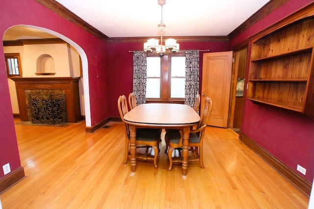 314 N Maple St, Itasca, IL 60143 - dining room featuring arched walkways, a chandelier, light wood-style flooring, and ornamental molding