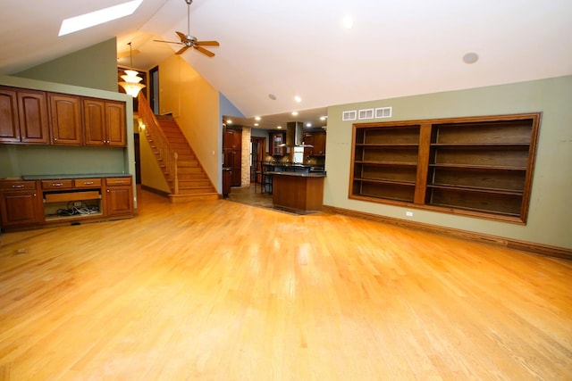 314 N Maple St, Itasca, IL 60143 - unfurnished living room with a skylight, light wood finished floors, vaulted ceiling, stairway, and a ceiling fan
