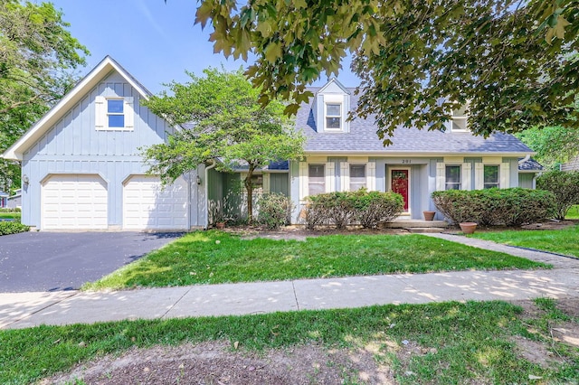 201 S Wulff St, Cary, IL 60013 - view of front of house with driveway, a garage, board and batten siding, a front yard, and roof with shingles