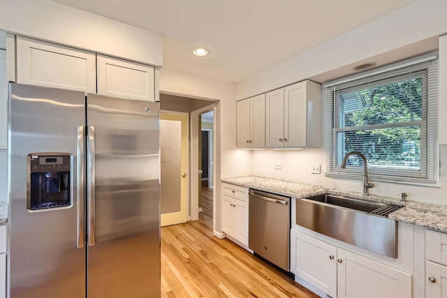 201 S Wulff St, Cary, IL 60013 - kitchen featuring appliances with stainless steel finishes, light wood-type flooring, recessed lighting, light stone countertops, and white cabinets