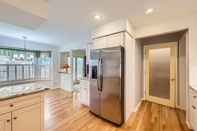 201 S Wulff St, Cary, IL 60013 - kitchen with stainless steel fridge, a chandelier, light wood-style floors, white cabinets, and recessed lighting
