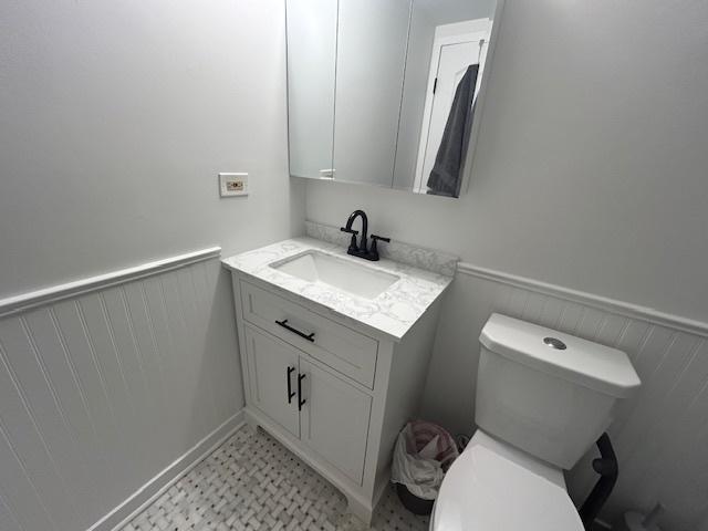 9098 Terrace Dr Unit 3E, Niles, IL 60714 - half bathroom featuring wainscoting, vanity, and tile patterned floors