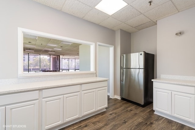 9098 Terrace Dr Unit 3E, Niles, IL 60714 - kitchen featuring freestanding refrigerator, dark wood-style flooring, a drop ceiling, white cabinetry, and light countertops