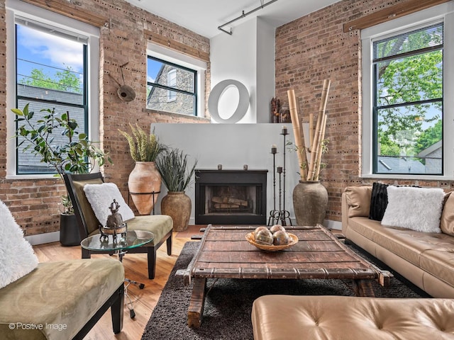 2035 W Charleston St Unit 205, Chicago, IL 60647 - living area featuring brick wall, healthy amount of natural light, light wood finished floors, track lighting, and a fireplace