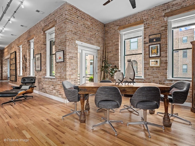 2035 W Charleston St Unit 205, Chicago, IL 60647 - dining area featuring brick wall, track lighting, wood finished floors, and a ceiling fan
